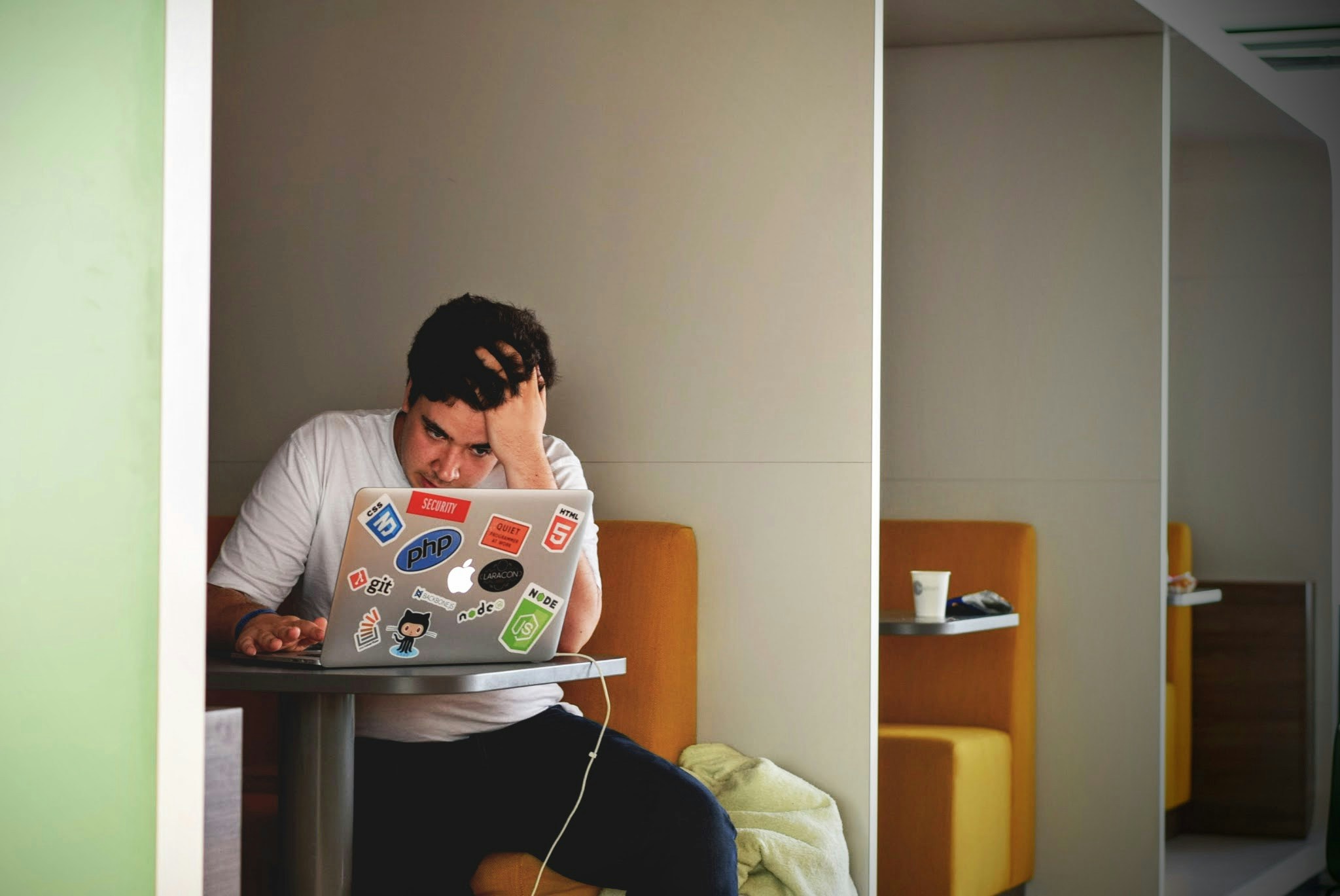 Man wearing white top using Macbook